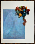 A square abstract art print featuring two large soft-edged blue oval shapes on a light blue background, displayed on a white sheet of paper with a colorful beaded ornament draped over the top-right corner.