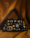 1950s black suede Gathered Charm Bag adorned with antique and vintage brass charms.