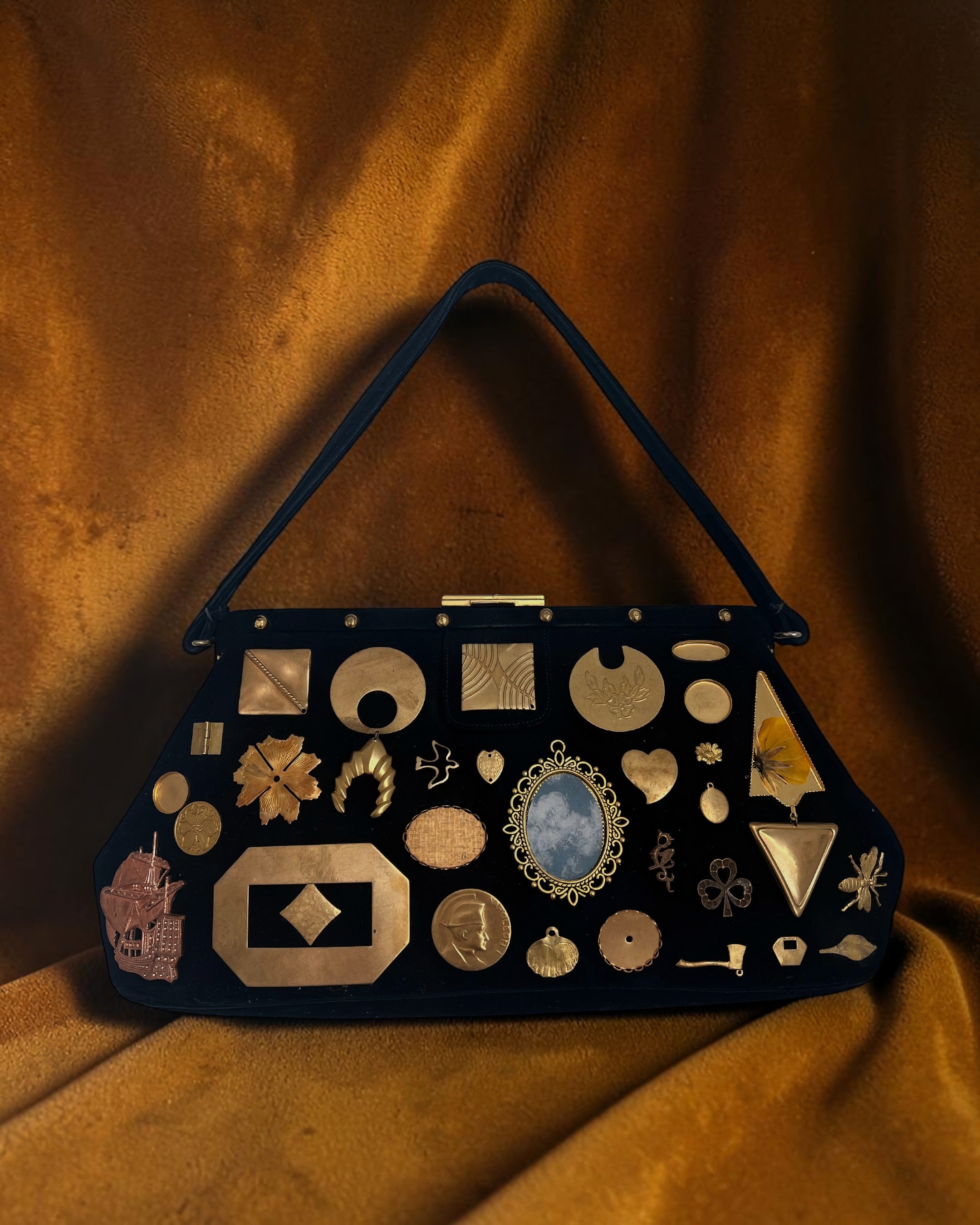 1950s black suede Gathered Charm Bag adorned with antique and vintage brass charms.